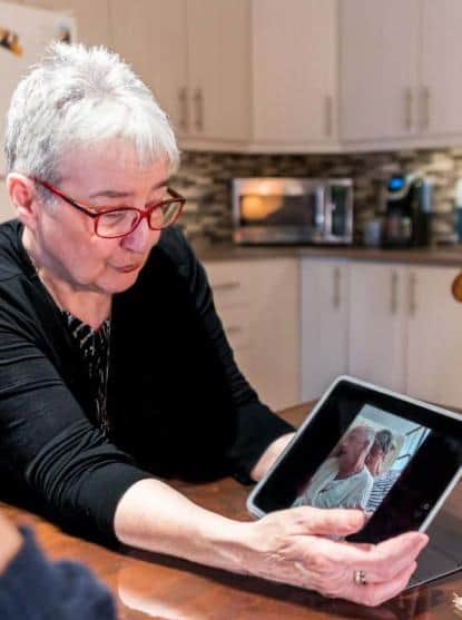 Martine montrant une photo de son mari alité (photo: Jean Bernier).