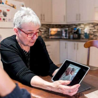 Martine montrant une photo de son mari alité (photo: Jean Bernier).